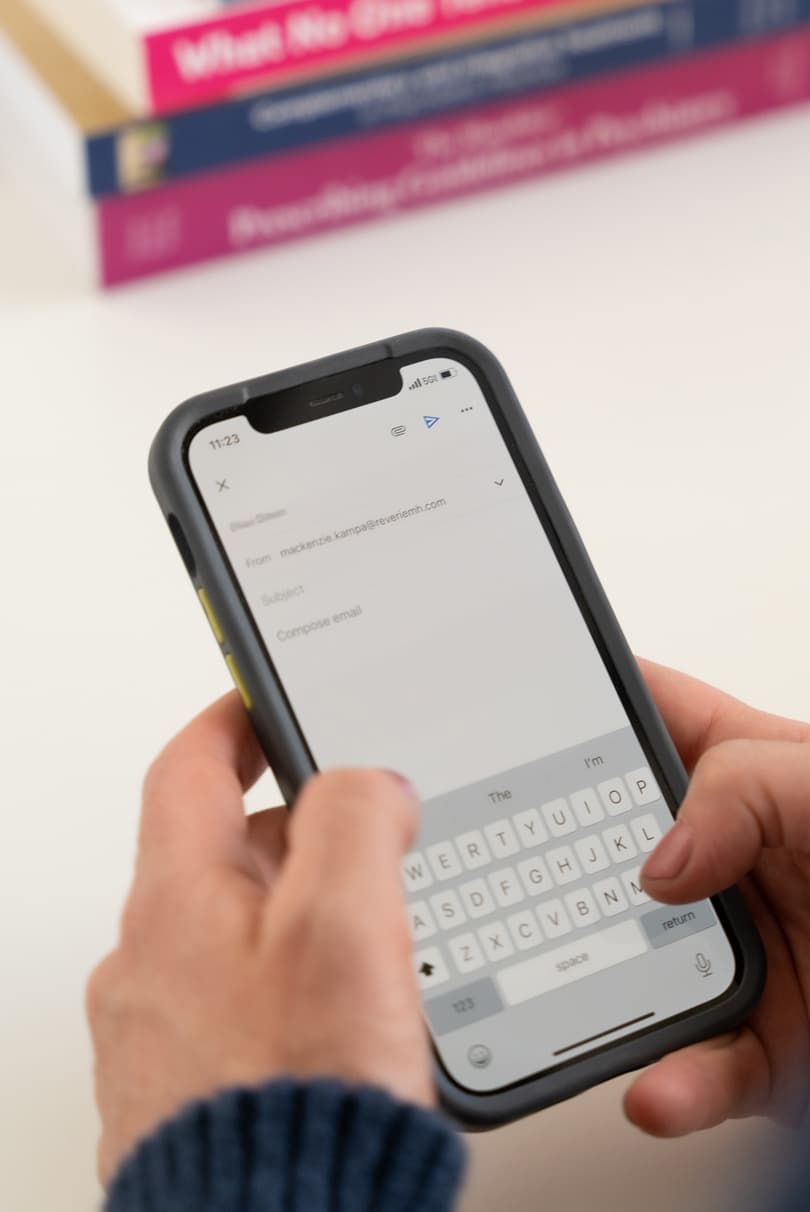 A closeup of MacKenzie writing an email to a patient from her phone