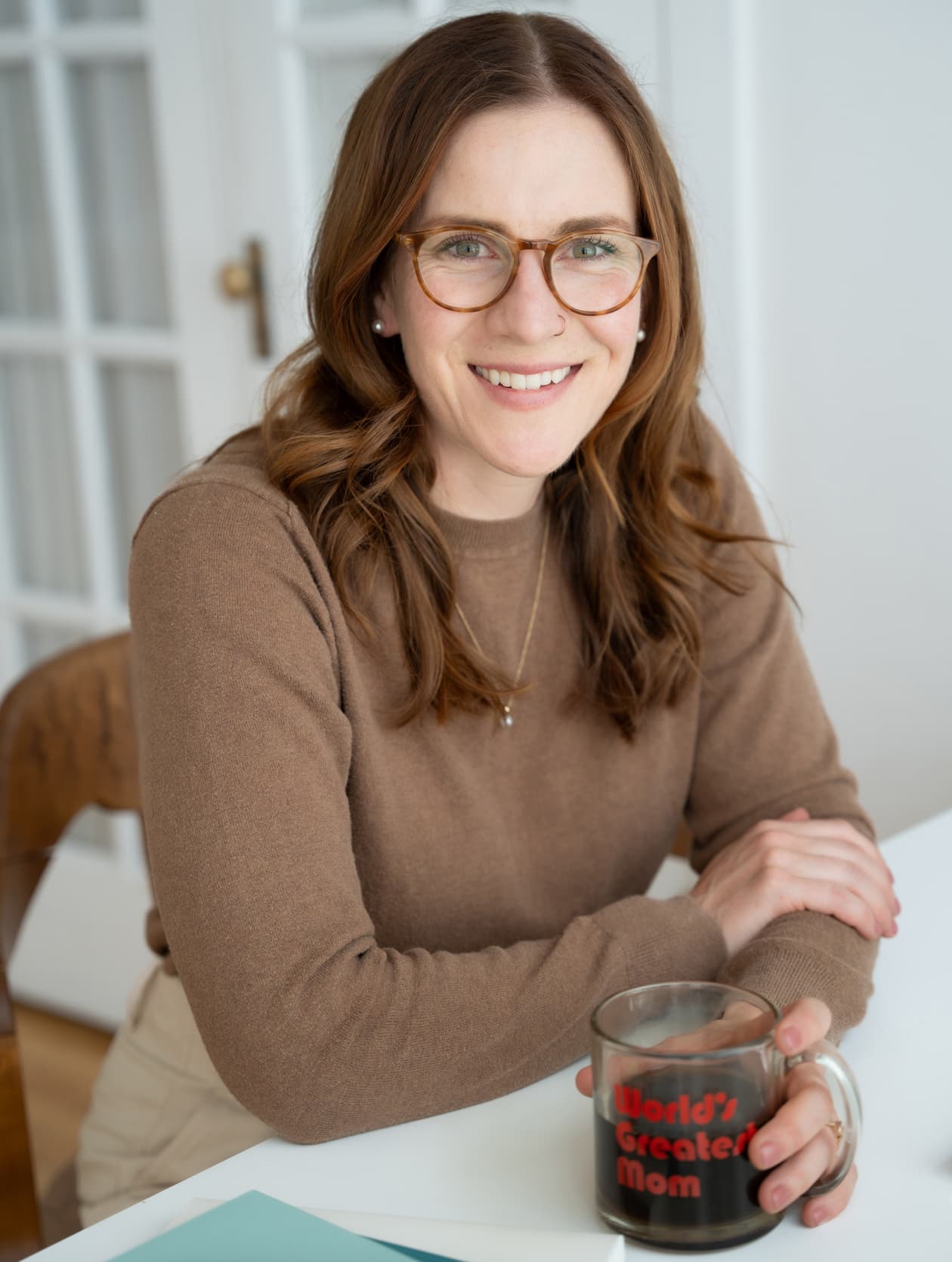 A picture of MacKenzie sitting at her desk, smiling at the camera